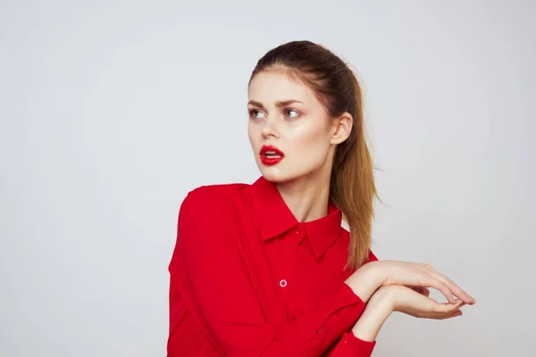 Retrato de una mujer con labios rojos en una camisa sobre un fondo claro recortado ver modelo maquillaje peinado —  Fotos de Stock