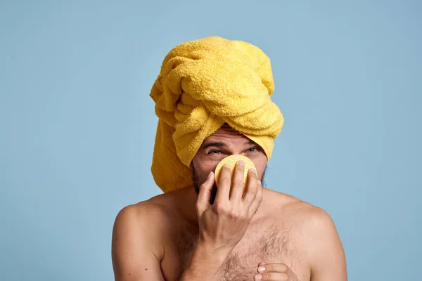 Um homem com uma toalha amarela em sua cabeça bum ombros nus pele limpa tomando um banho — Fotografia de Stock