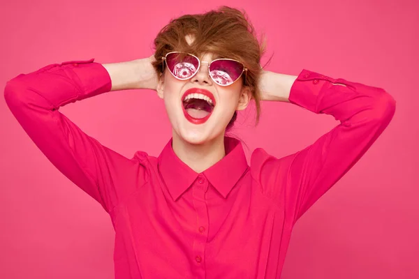 Fröhliche Frau mit Sonnenbrille, die ihr Haar mit Händen und rosa Hemd berührt — Stockfoto