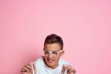 Çok renkli sıvı bir kimyasal maddenin ellerinde mataraları olan bir erkek laboratuvar asistanı.