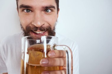 Büyük bir bardak birayla duygusal bir adam alkollü içki içiyor ve sarhoş halde el kol hareketi yapıyor.