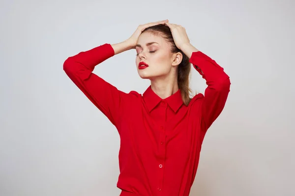 Retrato de una mujer con labios rojos en una camisa sobre un fondo claro recortado ver modelo maquillaje peinado — Foto de Stock