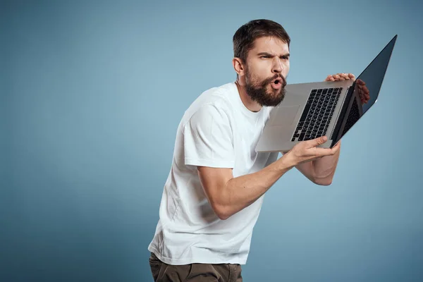 Emocional hombre con portátil en las manos en azul monitor de fondo teclado internet modelo recortado ver — Foto de Stock
