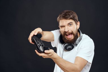 Elinde joystick olan bir adam kulaklıklar teknoloji eğlence oyun yaşam tarzı karanlık izole arka plan