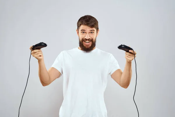 Een man met een joystick in zijn handen leuke spelletjes lifestyle wit t-shirt lichte achtergrond — Stockfoto