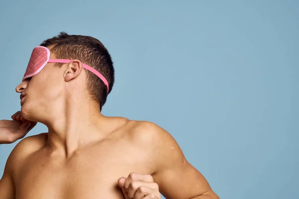 Uomo rilassato con maschera di sonno rosa su sfondo blu nudo torso vista ritagliata — Foto Stock