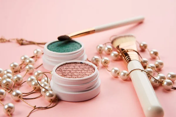 Kaca mata memiliki aksesoris manik-manik makeup sikat gigi koleksi kosmetik profesional pada latar belakang merah muda — Stok Foto