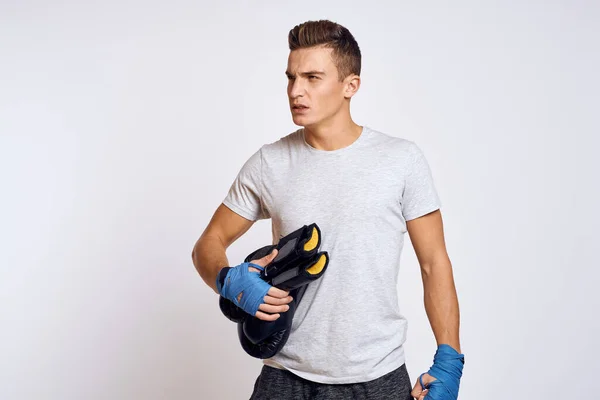 Homem forte com luvas de boxe e em uma camiseta branca em um fundo isolado vista cortada do modelo — Fotografia de Stock