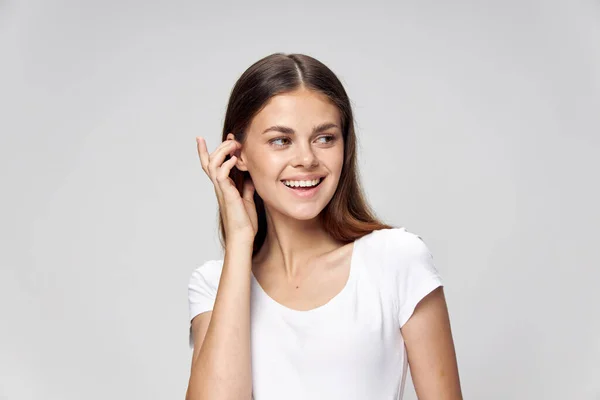 Veselá žena narovnává vlasy úsměv bílé tričko — Stock fotografie