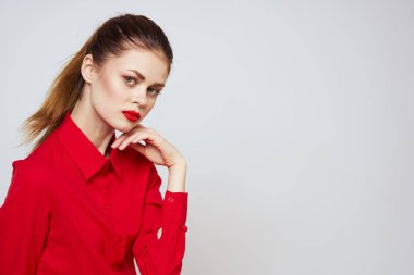 Açık arkaplanda kırmızı dudaklı bir kadının portresi. Makyaj modeli.