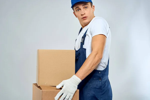 Pracovní muž v uniformě s krabicemi v jeho rukou dodávka nakladač životní styl — Stock fotografie