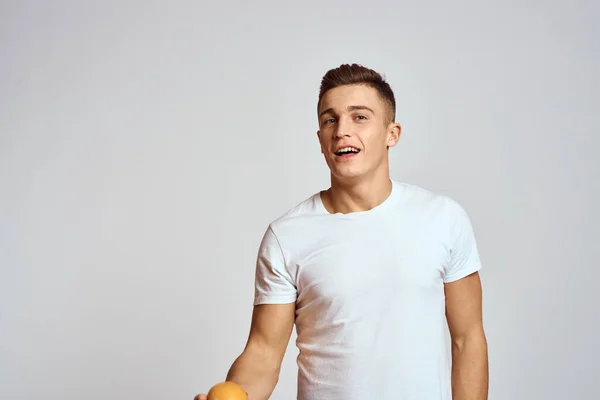 Een man met een oranje en een wit t-shirt op een lichte achtergrond bijgesneden weergave van het model — Stockfoto