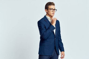 Gözlüklü bir iş adamı mavi takım elbiseli resmi ışık arkaplanı kesmiş.