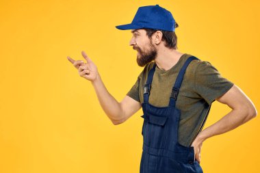 Üniformalı işçi, sarı arkaplan duygusuna hizmet ediyor.