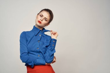 Mavi gömlekli ve kırmızı gözlüklü kadın model. Güzel yüz makyajı stüdyosu.