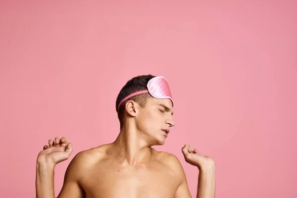 Homem em rosa máscara de sono no fundo rosa ombros nus manhã — Fotografia de Stock