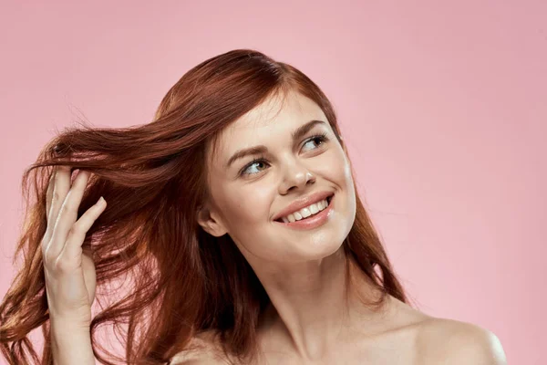 머리를 땋아 주는 아름다운 머리를 하고 있는 아리따운 여자 핑크 색 배경을 가진 미녀 — 스톡 사진
