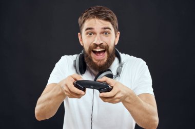 Elinde joystick olan bir adam kulaklıklar teknoloji eğlence oyun yaşam tarzı karanlık izole arka plan
