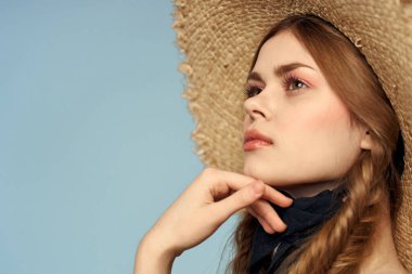 Hasır şapkalı kız portresi yakın çekim at kuyruğu eğlenceli kızıl saçlı mavi arka plan