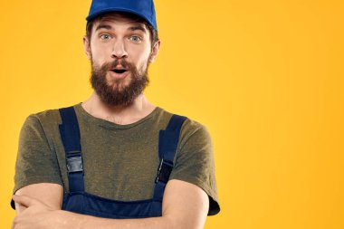 Üniformalı işçi, sarı arkaplan duygusuna hizmet ediyor.