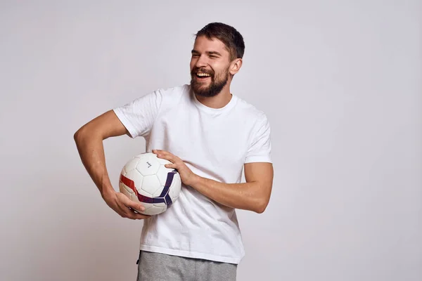 Allenatore maschile con un pallone da calcio in mano su uno sfondo leggero spiegazione energetica dei movimenti — Foto Stock