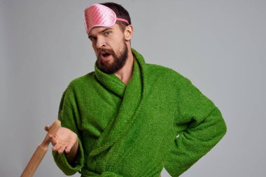 Elinde merdane olan adam yeşil cübbe pembe uyku maskesi kırpılmış manzara