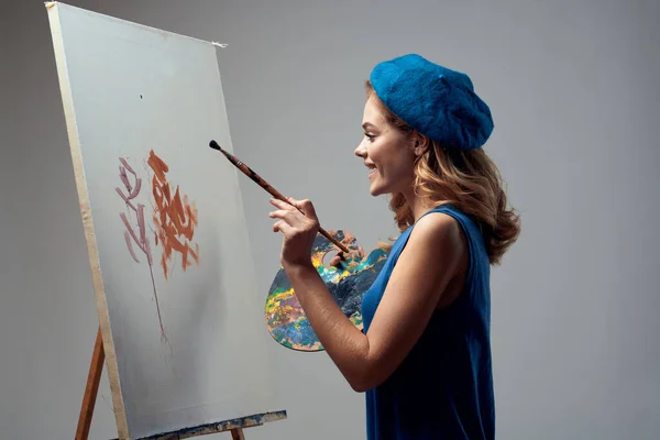 Mulher artista em azul boina paleta cavalete desenho arte criativo passatempo cinza fundo — Fotografia de Stock