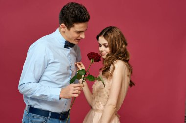 Kırmızı gülü seven romantik bir çiftin portresi izole edilmiş arka plan ve klasik gece elbisesi.