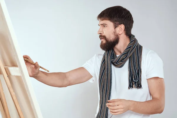 Ein Mann Künstler zeichnet auf einer Staffelei einen Schal weißes T-Shirt Kunst Hobby Kreativität — Stockfoto