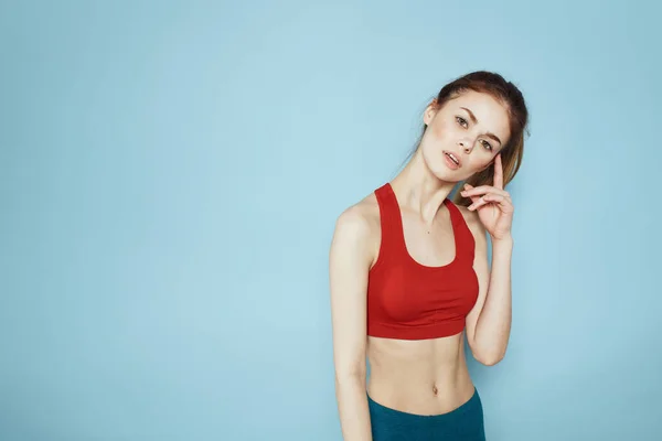 Sportieve vrouw rood tank top workout levensstijl gym blauw achtergrond — Stockfoto
