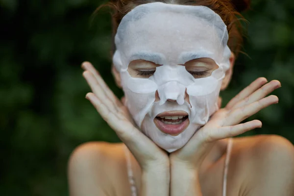 Piękna kobieta z zamkniętymi oczami pokazuje język Maska przeciwzmarszczkowa dermatologia — Zdjęcie stockowe