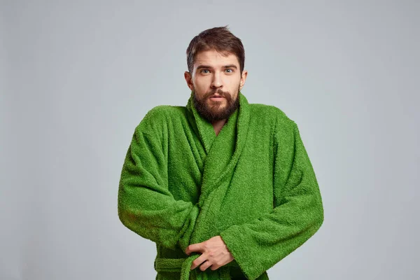 Vista de cerca de un hombre barbudo con una túnica verde sobre un fondo claro vista recortada — Foto de Stock