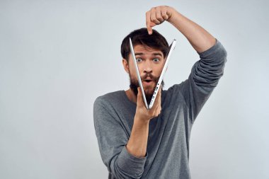 Dizüstü bilgisayarı olan duygusal bir adam. Modern tarz, hafif arka plan.