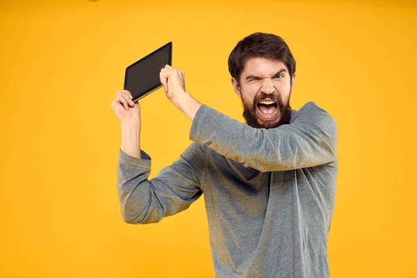 Бородатий чоловік з планшетом в руках технологія роботи бездротового пристрою жовтий фон — стокове фото