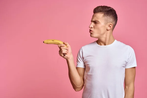 Hombre con frutas en las manos sobre un fondo rosa alimentos saludables vitaminas rosa fondo blanco camiseta modelo — Foto de Stock