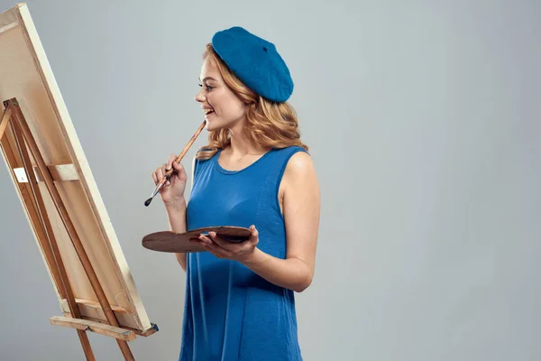 Frau Künstler blaue Baskenmütze Palette Zeichnung auf Staffelei Kunst Kreativität Licht Hintergrund — Stockfoto