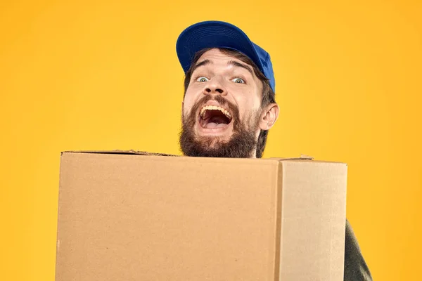 Um homem em uma forma de trabalho uma caixa com ferramentas de carregamento fundo amarelo — Fotografia de Stock