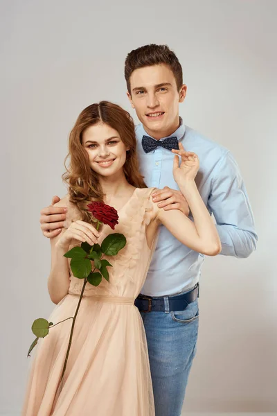 Young couple romance hug relationship dating red rose light studio background