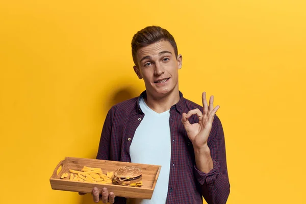 Συναισθηματικός άνθρωπος fast food τηγανητές πατάτες χάμπουργκερ lifestyle κίτρινο απομονωμένο φόντο — Φωτογραφία Αρχείου