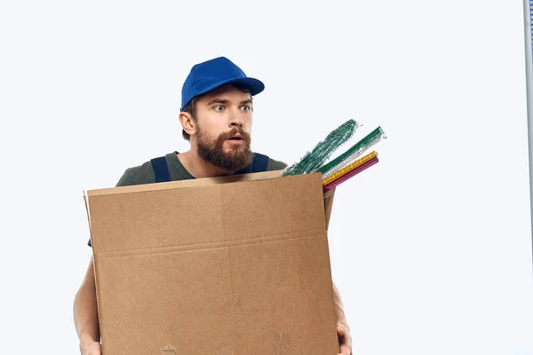 Um homem de uniforme de trabalho com uma caixa nas mãos trabalho de transporte de entrega — Fotografia de Stock