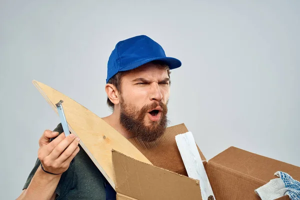 Hombre en uniforme de trabajo con caja en las manos herramientas estilo de vida fondo claro — Foto de Stock