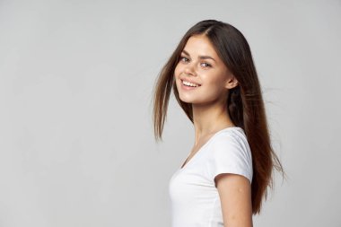 Beyaz tişörtlü mutlu kadın. Saçları açık. 