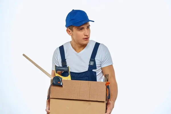 A man in a working uniform with a box in his hand loading a delivery service — Stock Photo, Image