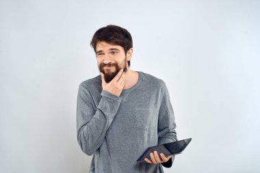 Elinde tablet olan sakallı bir adam. Gri ceketli, teknolojili, internet ışıklı bir arka plan.