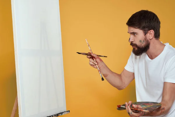 취미 생활의 창의성을 노란 배경으로 그린 남성 미술가 팔레트 이젤 — 스톡 사진