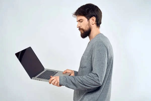 Un uomo in un maglione grigio con un computer portatile mani stile di vita tecnologia comunicazione internet lavoro — Foto Stock