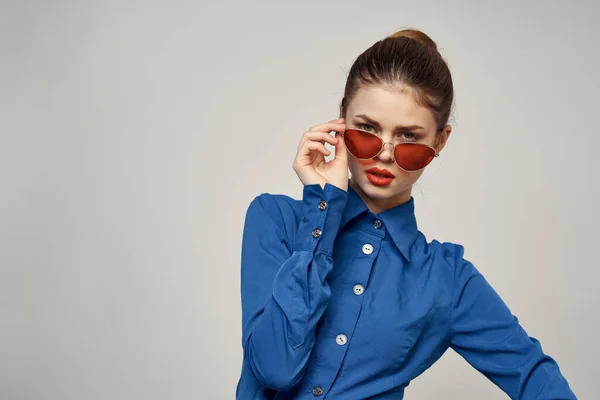 선글라스를 끼고 밝은 배경에 푸른 셔츠를 입은 여성의 모습 모델 카피 스페이스의 모습 — 스톡 사진