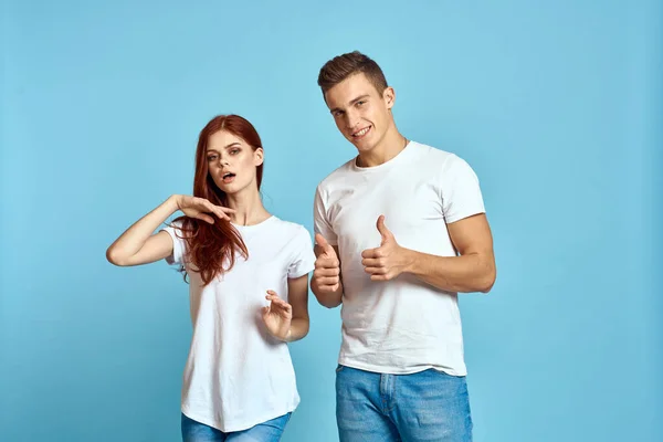 Verliebte Männer und Frauen in Jeans und T-Shirt vor blauem Hintergrund umarmen sich und haben Spaß — Stockfoto