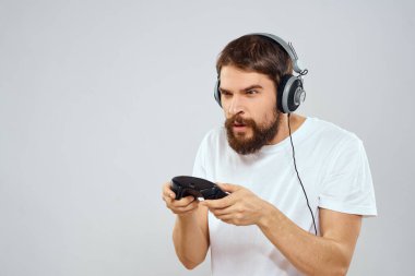 Gamepad 'li kulaklıklı bir adam hobi hayatı tarzı hafif arka planda oynuyor.