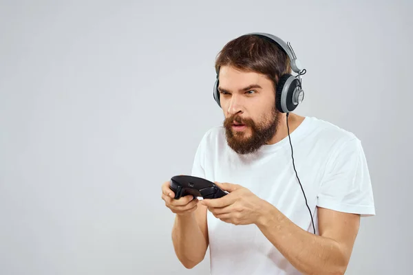Hombre en auriculares con gamepad jugando hobby entretenimiento estilo de vida luz fondo —  Fotos de Stock